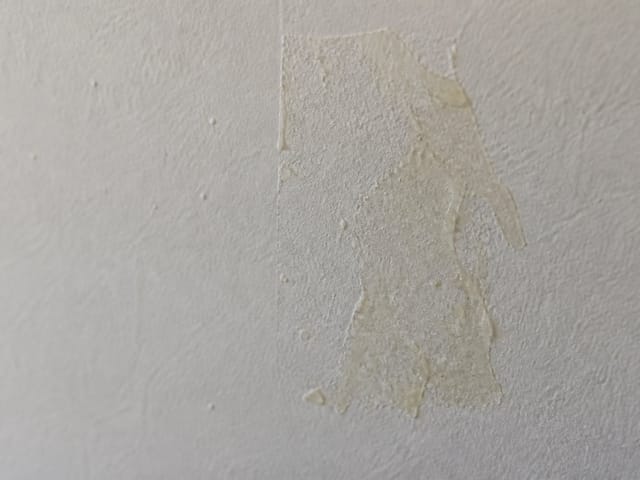 Résidu de ruban adhésif sur un mur peint