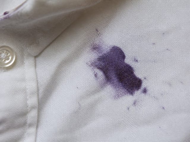 Mancha de arándano en una camisa blanca