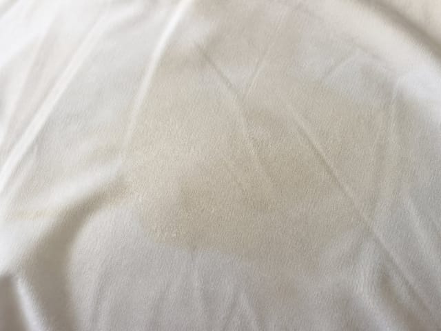 Traces de sébum sur une taie d'oreiller blanche