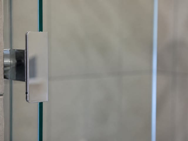Close-up of a frameless glass shower door