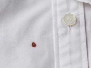 Petite tache de sang séché sur une chemise blanche