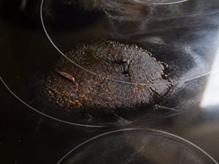 Résidus d'aliments brûlés sur une table de cuisson en verre
