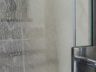 Résidus de savon sur une porte de douche vitrée